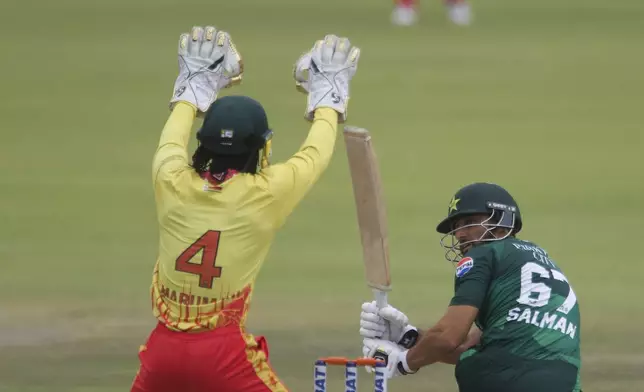 Zimbabwe's Tadiwanashe Marumani, left, and Pakistan's Salman Ali Agha during the third T20 cricket match between Zimbabwe and Pakistan at Queens Sports Club in Bulawayo, Zimbabwe, Thursday, Dec. 5, 2024. (AP Photo/Wonder Mashura)