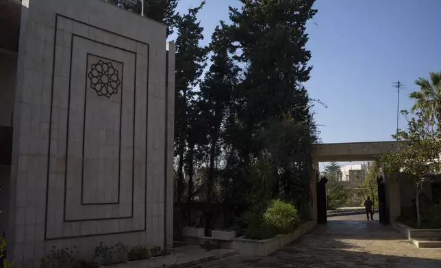 A man leaves a damaged property owned by ousted Syrian President Bashar Assad's family, in Qardaha, Syria, on Tuesday, Dec. 17, 2024. (AP Photo/Leo Correa)