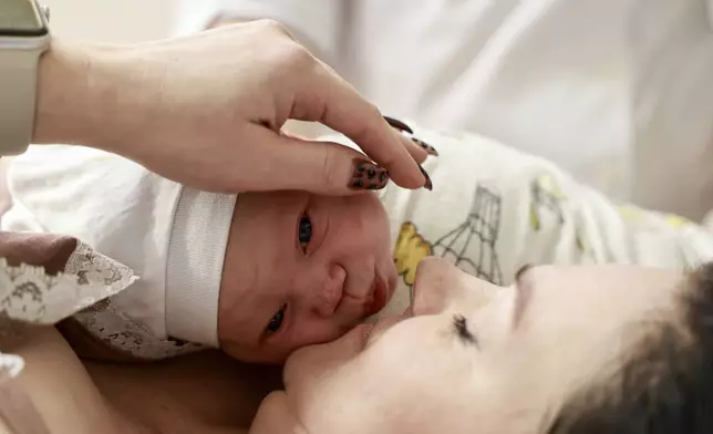 Yulia Ponomarenko kisses her newborn baby Marianna, at the maternity hospital №7 in Odesa, Ukraine, Monday, Nov. 11, 2024 (AP Photo/Nina Lyashonok)