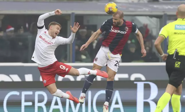 Fiorentina's Lucas Beltran, left, fights for the ball with Bologna's Lorenzo De Silvestri during the Serie A soccer match between Bologna and Fiorentina, at Renato Dall'Ara Stadium in Bologna, Italy, Sunday Dec. 15, 2024. (Michele Nucci /LaPresse via AP)