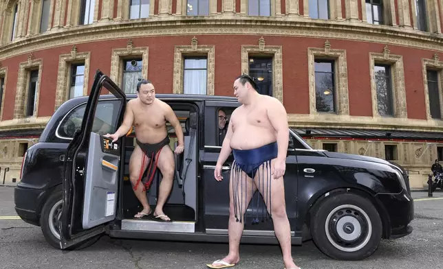 Rishikis from Japan's Sumo Kyokai, Daisuke Kitanowaka, right, and Akira Fukutsuumi pose for a photo call outside of London's Royal Albert Hall in London, Wednesday, Dec. 4, 2024 where the UK's second ever official basho will take place in October of next year. (AP Photo/Thomas Krych)