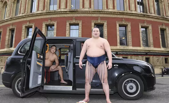 Rishikis from Japan's Sumo Kyokai, Daisuke Kitanowaka, right, and Akira Fukutsuumi pose for a photo call outside of London's Royal Albert Hall in London, Wednesday, Dec. 4, 2024 where the UK's second ever official basho will take place in October of next year. (AP Photo/Thomas Krych)