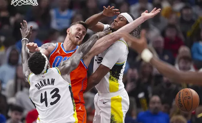 Oklahoma City Thunder center Isaiah Hartenstein (55) looses the ball as he's fouled by Indiana Pacers forward Pascal Siakam (43) and center Myles Turner (33) during the second half of an NBA basketball game in Indianapolis, Thursday, Dec. 26, 2024. (AP Photo/Michael Conroy)