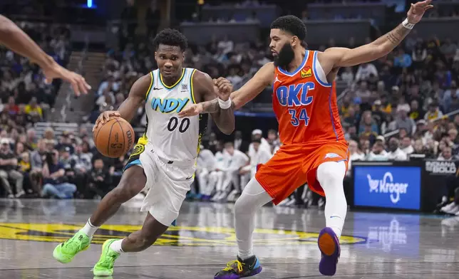 Indiana Pacers guard Bennedict Mathurin (00) drives on Oklahoma City Thunder forward Kenrich Williams (34) during the second half of an NBA basketball game in Indianapolis, Thursday, Dec. 26, 2024. (AP Photo/Michael Conroy)