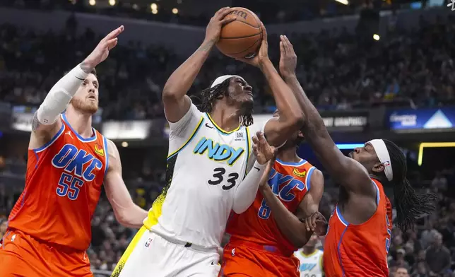 Indiana Pacers center Myles Turner (33) is fouled as he shoots by Oklahoma City Thunder guard Luguentz Dort (5) during the second half of an NBA basketball game in Indianapolis, Thursday, Dec. 26, 2024. (AP Photo/Michael Conroy)