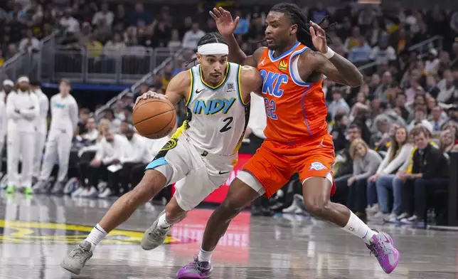 Indiana Pacers guard Andrew Nembhard (2) drives on Oklahoma City Thunder guard Cason Wallace (22) during the second half of an NBA basketball game in Indianapolis, Thursday, Dec. 26, 2024. (AP Photo/Michael Conroy)