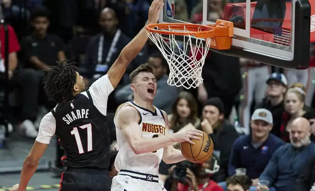 Denver Nuggets guard Christian Braun, right, shoots over Portland Trail Blazers guard Shaedon Sharpe during the second half of an NBA basketball game in Portland, Ore., Thursday, Dec. 19, 2024. (AP Photo/Craig Mitchelldyer)