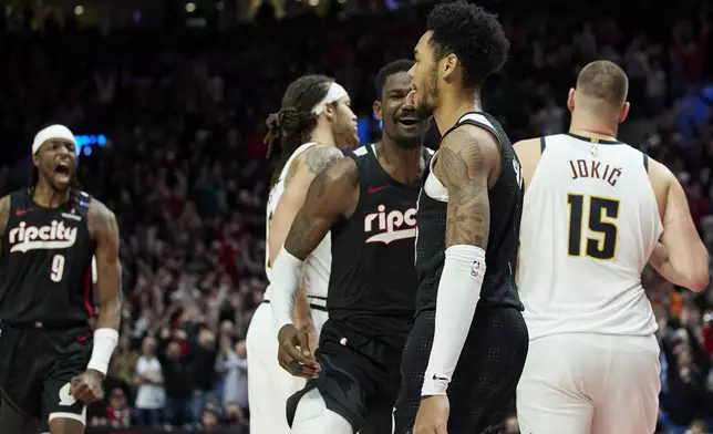 Portland Trail Blazers guard Anfernee Simons, front, reacts after making a game-winning basket against the Denver Nuggets during the second half of an NBA basketball game in Portland, Ore., Thursday, Dec. 19, 2024. (AP Photo/Craig Mitchelldyer)