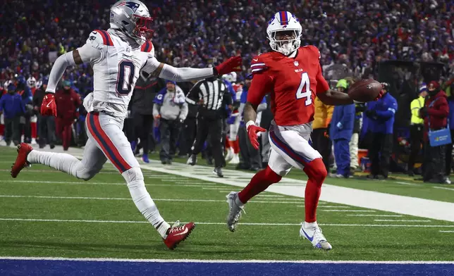 Buffalo Bills running back James Cook (4) carries the ball into the end zone against New England Patriots cornerback Christian Gonzalez (0) for a touchdown against the during the second quarter of an NFL football game, Sunday, Dec. 22, 2024, in Orchard Park, N.Y.. (AP Photo/Jeffrey T. Barnes)