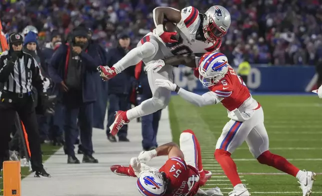 New England Patriots running back Rhamondre Stevenson (38) is forced out of bounds by Buffalo Bills cornerback Kaiir Elam (5) and linebacker Baylon Spector (54) during the second quarter of an NFL football game, Sunday, Dec. 22, 2024, in Orchard Park, N.Y.. (AP Photo/Gene J. Puskar)