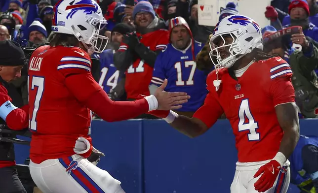 Buffalo Bills quarterback Josh Allen (17) congratulates Buffalo Bills running back James Cook (4) after a touchdown against the New England Patriots during the third quarter of an NFL football game, Sunday, Dec. 22, 2024, in Orchard Park, N.Y.. (AP Photo/Jeffrey T. Barnes)