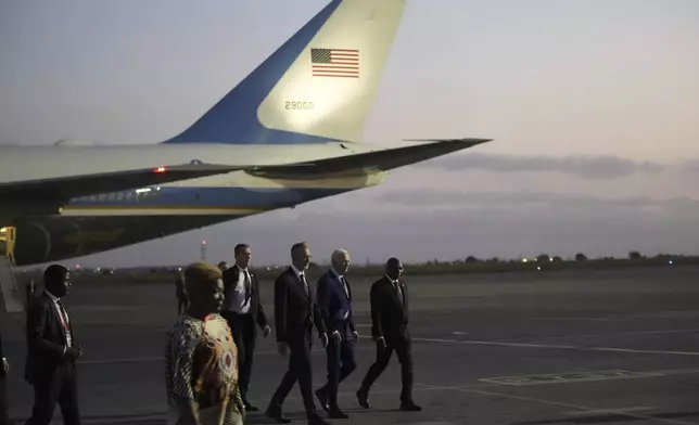 President Joe Biden walks with Angolan Foreign Minister Tete Antonio, right, after arriving at Quatro de Fevereiro international airport in the capital Luanda, Angola on Monday, Dec. 2, 2024, on his long-promised visit to Africa. (AP Photo/Ben Curtis)