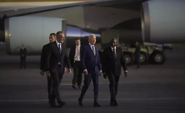 President Joe Biden is greeted by Angolan Foreign Minister Tete Antonio, right, as he arrives at Quatro de Fevereiro international airport in the capital Luanda, Angola on Monday, Dec. 2, 2024, on his long-promised visit to Africa. (AP Photo/Ben Curtis)