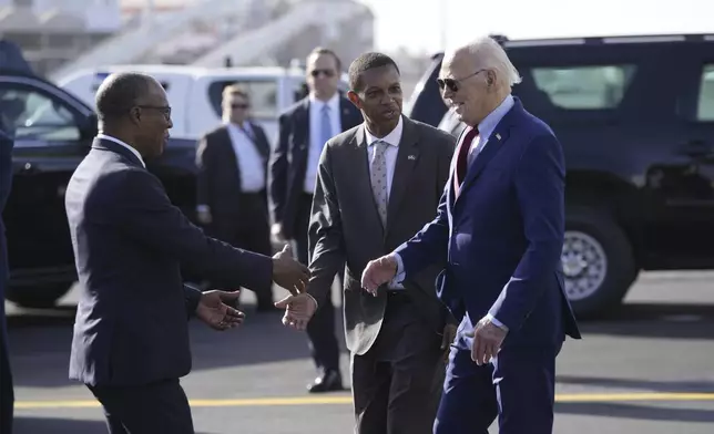 President Joe Biden is greeted by Cape Verde's Prime Minister Ulisses Correia e Silva at Amilcar Cabral international airport on Sal island, Cape Verde Monday, Dec. 2, 2024, en route to Angola as he makes his long-promised visit to Africa. (AP Photo/Ben Curtis)