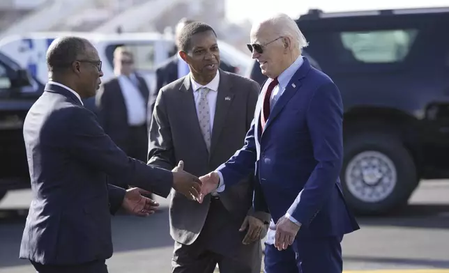 President Joe Biden is greeted by Cape Verde's Prime Minister Ulisses Correia e Silva at Amilcar Cabral international airport on Sal island, Cape Verde Monday, Dec. 2, 2024, en route to Angola as he makes his long-promised visit to Africa. (AP Photo/Ben Curtis)