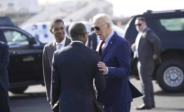 With Jose Luis Livramento, Cabo Verde Ambassador to the U.S looking on, President Joe Biden is greeted by Cape Verde's Prime Minister Ulisses Correia e Silva at Amilcar Cabral international airport on Sal island, Cape Verde Monday, Dec. 2, 2024, en route to Angola as he makes his long-promised visit to Africa. (AP Photo/Ben Curtis)