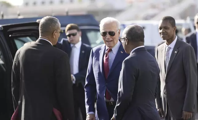 President Joe Biden speaks with Cape Verde's Prime Minister Ulisses Correia e Silva , right, and Jose Luis Livramento, Cabo Verde Ambassador to the U.S at Amilcar Cabral international airport on Sal island, Cape Verde Monday, Dec. 2, 2024, en route to Angola as he makes his long-promised visit to Africa. (AP Photo/Ben Curtis)