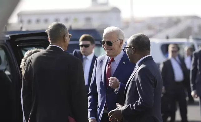 President Joe Biden speaks with Cape Verde's Prime Minister Ulisses Correia e Silva, right, and Jose Luis Livramento, Cabo Verde Ambassador to the U.S at Amilcar Cabral international airport on Sal island, Cape Verde Monday, Dec. 2, 2024, en route to Angola as he makes his long-promised visit to Africa. (AP Photo/Ben Curtis)