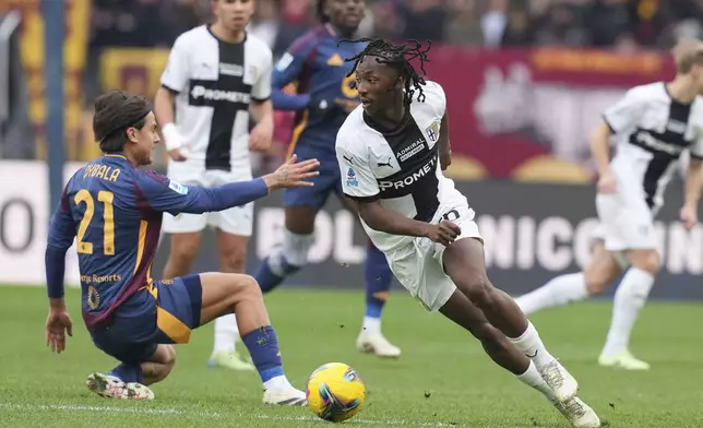 Parma's Woyo Coulibaly, right, takes on Roma's Paulo Dybala during the Italian Serie A soccer match between Roma and Parma at Rome's Olympic stadium, Sunday Dec. 22, 2024. (Alfredo Falcone/LaPresse via AP)