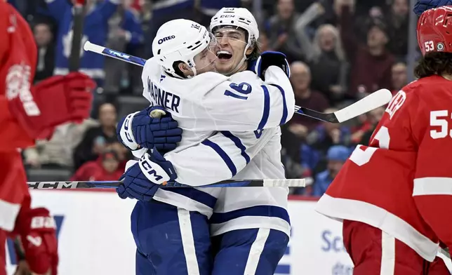 Toronto Maple Leafs left wing Matthew Knies (23) celebrates with right wing Mitch Marner (16) after scoring a goal against the Detroit Red Wings during the third period of an NHL hockey game, Saturday, Dec. 14, 2024 in Detroit. (AP Photo/Lon Horwedel)