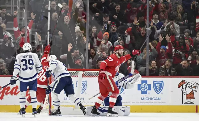 Detroit Red Wings center Michael Rasmussen (27) reacts with the fans after Detroit Red Wings defenseman Jeff Petry (46) scored a goal against the Toronto Maple Leafs during the first period of an NHL hockey game, Saturday, Dec. 14, 2024 in Detroit. (AP Photo/Lon Horwedel)