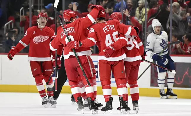 Detroit Red Wings defenseman Jeff Petry (46) celebrates with his teammates after scoring a goal against the Toronto Maple Leafs during the first period of an NHL hockey game, Saturday, Dec. 14, 2024 in Detroit. (AP Photo/Lon Horwedel)