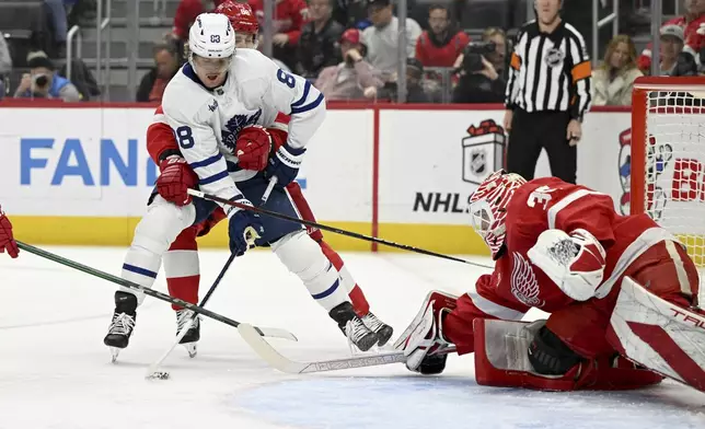 Toronto Maple Leafs right wing William Nylander (88) is held from behind by Detroit Red Wings right wing Patrick Kane (88) while trying to get a shot on goal against Red Wings goaltender Ville Husso (35) during the first period of an NHL hockey game, Saturday, Dec. 14, 2024 in Detroit. (AP Photo/Lon Horwedel)