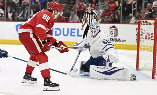 Toronto Maple Leafs goaltender Joseph Woll (60) stops a shot on goal by Detroit Red Wings right wing Patrick Kane (88) during the second period of an NHL hockey game, Saturday, Dec. 14, 2024 in Detroit. (AP Photo/Lon Horwedel)