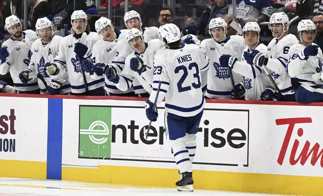 Toronto Maple Leafs left wing Matthew Knies (23) celebrates with teammates on the bench after scoring a goal against the Detroit Red Wings during the third period of an NHL hockey game, Saturday, Dec. 14, 2024 in Detroit. (AP Photo/Lon Horwedel)