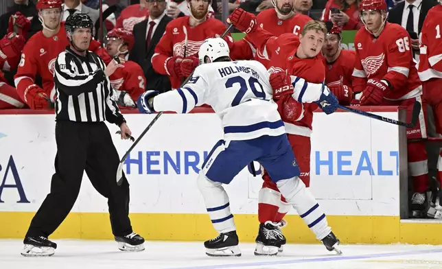 Detroit Red Wings right wing Jonatan Berggren (48) scuffles with Toronto Maple Leafs right wing Pontus Holmberg (29) who pulled off Berggren's helmet during the second period of an NHL hockey game, Saturday, Dec. 14, 2024 in Detroit. (AP Photo/Lon Horwedel)