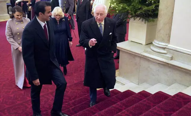 Britain's King Charles III, right, and Britain's Queen Camilla, behind, walk with the Emir of Qatar Sheikh Tamim bin Hamad Al Thani, foreground left, and his wife Sheikha Jawaher during the state visit to the UK of the Emir of Qatar, in London, Tuesday, Dec. 3, 2024. (Jonathan Brady via AP, Pool)