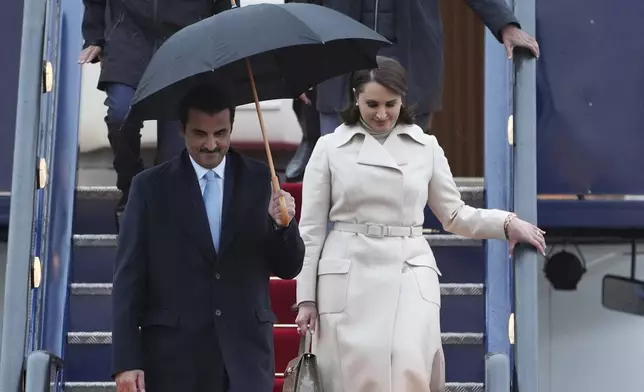 Emir of Qatar Sheikh Tamim bin Hamad bin Khalifa Al Thani, front left, and Sheikha Hind bint Hamad bin Khalifa al-Thani, front right, arrive at Stansted Airport in Essex, England, Monday Dec. 2, 2024, for a state visit hosted by King Charles III. ( Joe Giddens/PA via AP)