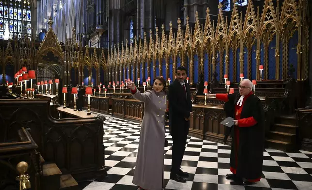 Qatar's Emir Sheikh Tamim bin Hamad al-Thani, center, and his wife Sheikha Jawaher bint Hamad bin Suhaim al-Thani, left, react during a visit to Westminster Abbey with Westminster Dean David Hoyle, in London, Tuesday, Dec. 3, 2024, on the first day of their two-day State Visit to Britain. ( Justin Tallis/Pool photo via AP)