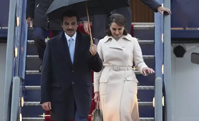 Emir of Qatar Sheikh Tamim bin Hamad bin Khalifa Al Thani, front left, and Sheikha Hind bint Hamad bin Khalifa al-Thani, front right, arrive at Stansted Airport in Essex, England, Monday Dec. 2, 2024, for a state visit hosted by King Charles III. ( Joe Giddens/PA via AP)