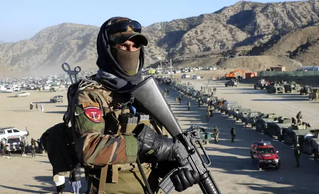 Taliban fighters stand guard during the funeral prayers of Khalil Haqqani, the minister for refugees and repatriation, during his funeral procession in eastern Paktia province, Afghanistan, Thursday, Dec. 12, 2024. (AP Photo/Saifullah Zahir)