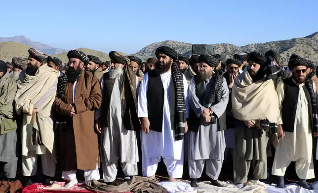 Foreign Minister Amir Khan Muttaqi, center, and mourners offer funeral prayers of Khalil Haqqani, the minister for refugees and repatriation, during his funeral procession in eastern Paktia province, Afghanistan, Thursday, Dec. 12, 2024. (AP Photo/Saifullah Zahir)