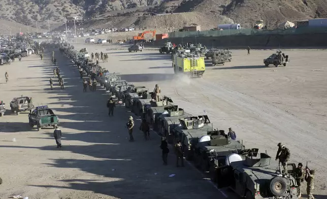 Taliban fighters stand guard during the funeral prayers of Khalil Haqqani, the minister for refugees and repatriation, during his funeral procession in eastern Paktia province, Afghanistan, Thursday, Dec. 12, 2024. (AP Photo/Saifullah Zahir)