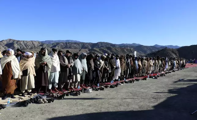 People attend the funeral prayer of Khalil Haqqani, the minister for refugees and repatriation, during his funeral procession in eastern Paktia province, Afghanistan, Thursday, Dec. 12, 2024. (AP Photo/Saifullah Zahir)