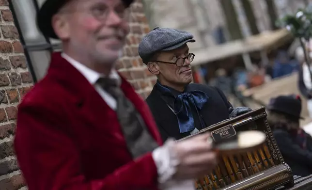 People in costumes from Charles Dickens' 19th-century English era take part in a Dickens Festival, in Deventer, Netherlands, Saturday, Dec. 14, 2024. (AP Photo/Peter Dejong)