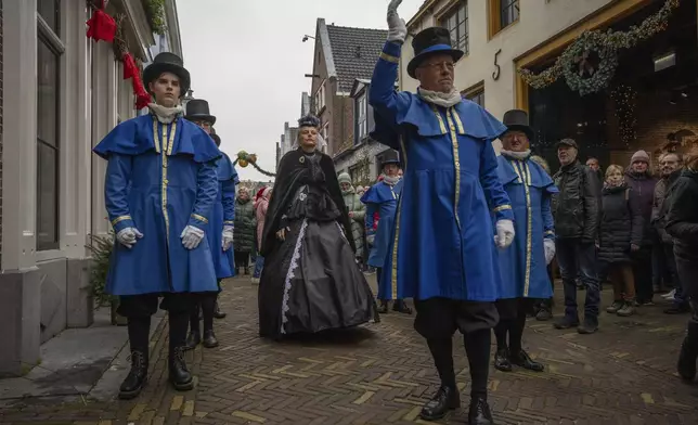 Sandra Nieland plays Queen Victoria a people in costumes from Charles Dickens' 19th-century English era take part in a Dickens Festival, in Deventer, Netherlands, Saturday, Dec. 14, 2024. (AP Photo/Peter Dejong)