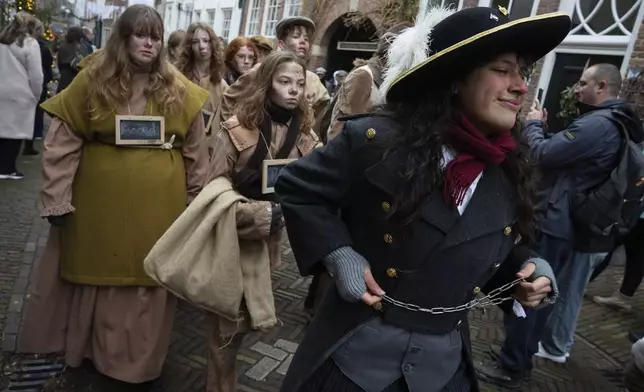 People in costumes from Charles Dickens' 19th-century English era take part in a Dickens Festival, in Deventer, Netherlands, Saturday, Dec. 14, 2024. (AP Photo/Peter Dejong)