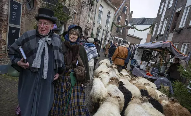 People in costumes from Charles Dickens' 19th-century English era take part in a Dickens Festival, in Deventer, Netherlands, Saturday, Dec. 14, 2024. (AP Photo/Peter Dejong)