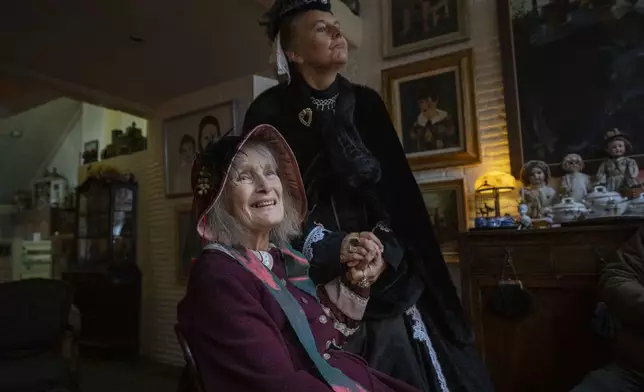 Emmy Strik, left, who started the Deventer Dickens Day, and Sandra Nieland who plays Queen Victoria, are interviewed as people in costumes from Charles Dickens' 19th-century English era take part in a Dickens Festival, in Deventer, Netherlands, Saturday, Dec. 14, 2024. (AP Photo/Peter Dejong)