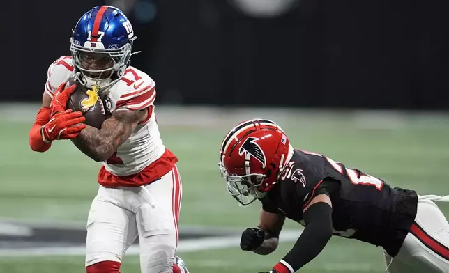 New York Giants wide receiver Wan'Dale Robinson (17) runs the ball against Atlanta Falcons cornerback Mike Hughes (21) in the first half of an NFL football game in Atlanta, Sunday, Dec. 22, 2024. (AP Photo/Mike Stewart)