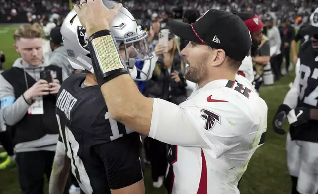 Atlanta Falcons quarterback Kirk Cousins (18) greets Las Vegas Raiders quarterback Desmond Ridder (10) after an NFL football game, Monday, Dec. 16, 2024, in Las Vegas. (AP Photo/Rick Scuteri)