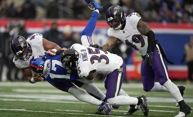 Baltimore Ravens linebacker Malik Harrison (40), cornerback Desmond King II (35) and linebacker Chris Board (49) tackle New York Giants wide receiver Wan'Dale Robinson (17) during the fourth quarter of an NFL football game, Sunday, Dec. 15, 2024, in East Rutherford, N.J. (AP Photo/Frank Franklin II)