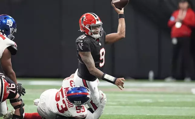 Atlanta Falcons quarterback Michael Penix Jr. (9) is tackled by New York Giants linebacker Darius Muasau (53) in the first half of an NFL football game against the in Atlanta, Sunday, Dec. 22, 2024. (AP Photo/Mike Stewart)