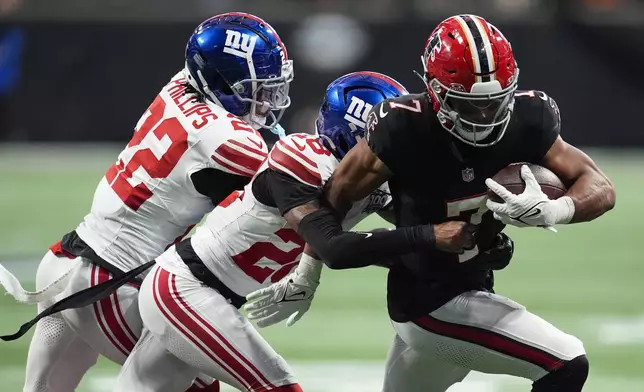 Atlanta Falcons running back Bijan Robinson (7) runs the ball against New York Giants cornerback Cor'Dale Flott (28) in the second half of an NFL football game in Atlanta, Sunday, Dec. 22, 2024. (AP Photo/Mike Stewart)