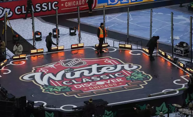 Workers clear off the stage on the day before the NHL Winter Classic outdoor hockey game featuring the Chicago Blackhawks and the St. Louis Blues at Wrigley Field, Monday, Dec. 30, 2024, in Chicago. (AP Photo/Erin Hooley)