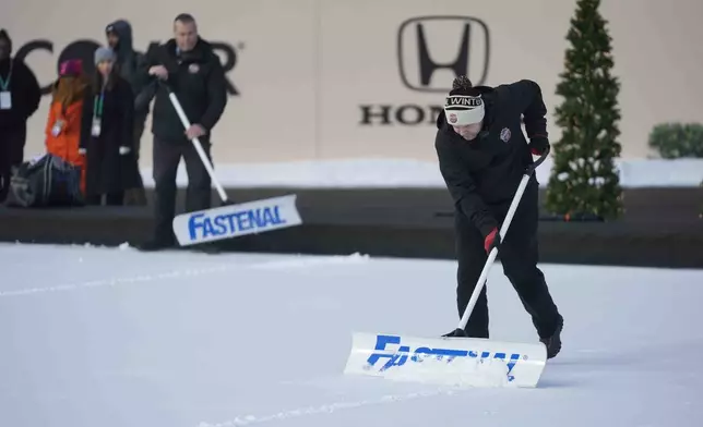 Workers clear ice on the day before the NHL Winter Classic outdoor hockey game featuring the Chicago Blackhawks and the St. Louis Blues at Wrigley Field, Monday, Dec. 30, 2024, in Chicago. (AP Photo/Erin Hooley)